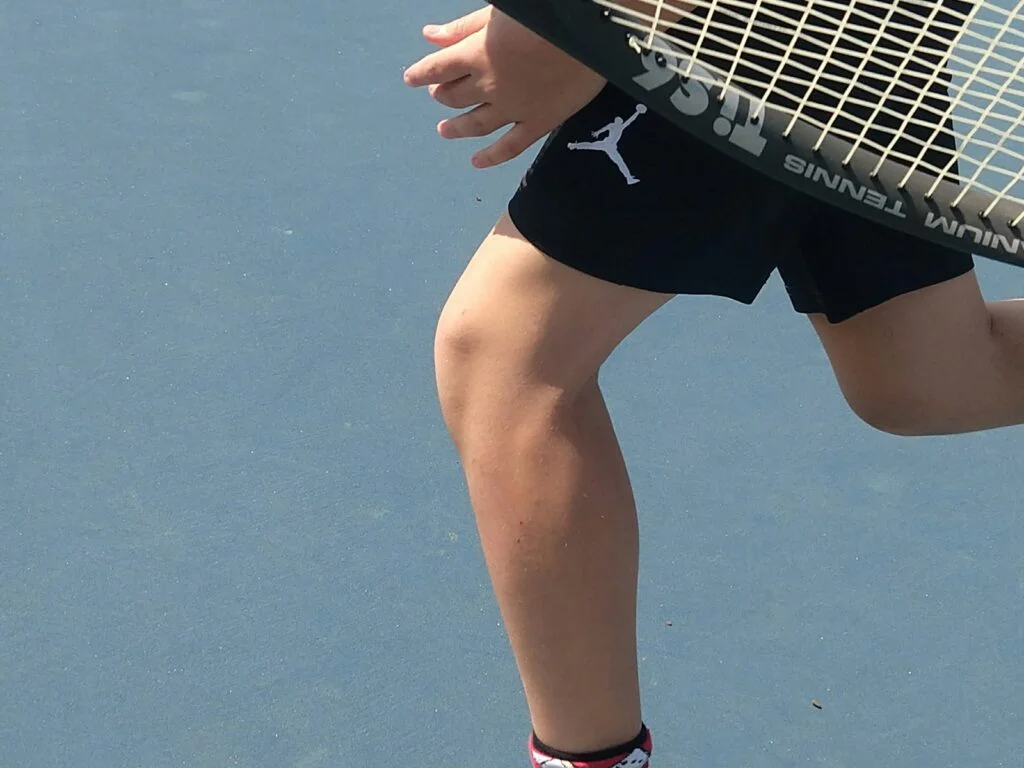 a man holding a tennis racquet on top of a tennis court