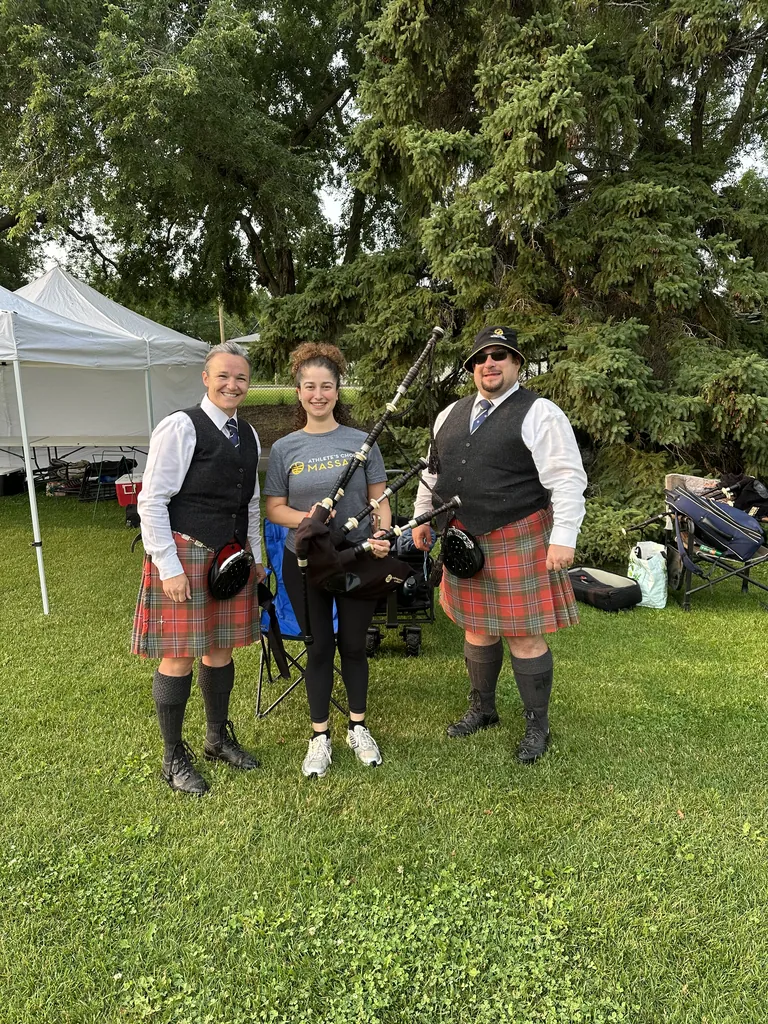 An Athlete's Choice Massage therapist with two pipers at the Sherwood Park Highland Gathering
