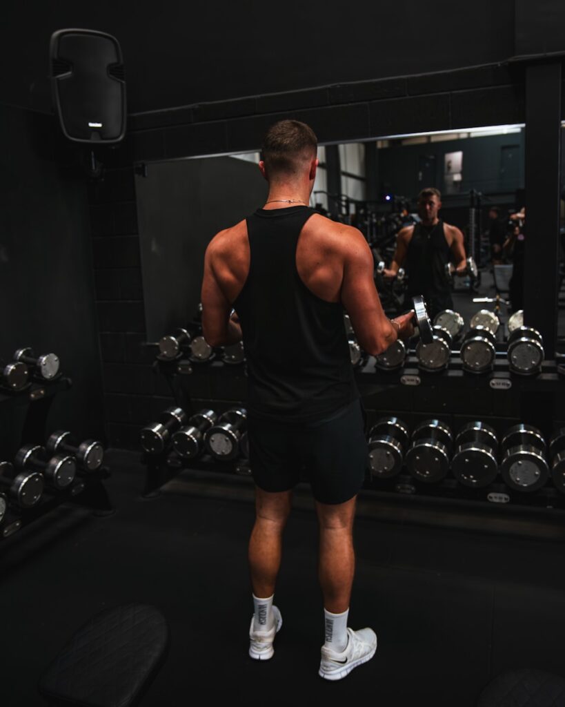 a man standing in front of a mirror in a gym