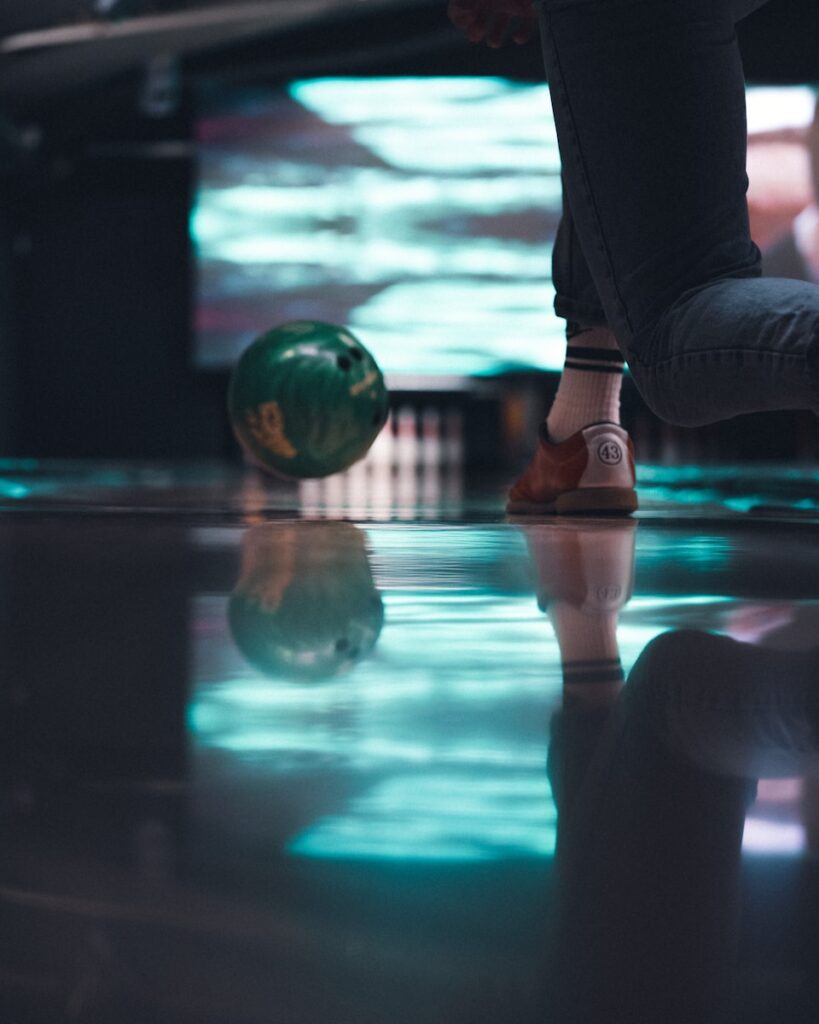 person in black pants and brown shoes sitting on glass ball