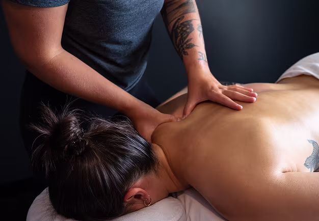 Registered massage therapist providing therapeutic massage to relieve muscle tension and promote recovery.